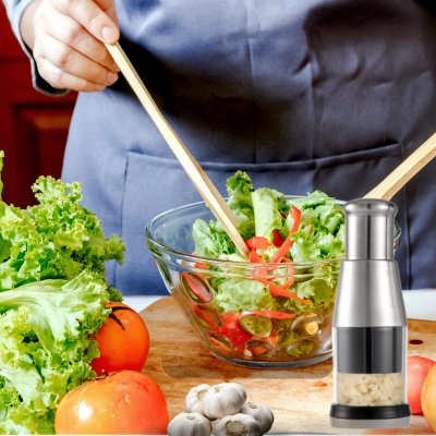 Mini hachoir sur une planche en bois coté de bol de salade