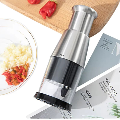 Mini-hachoir sur une planche en bois et a coté une assiette 