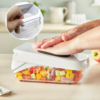 Femme pressant coupe legume avec des legumes coupes